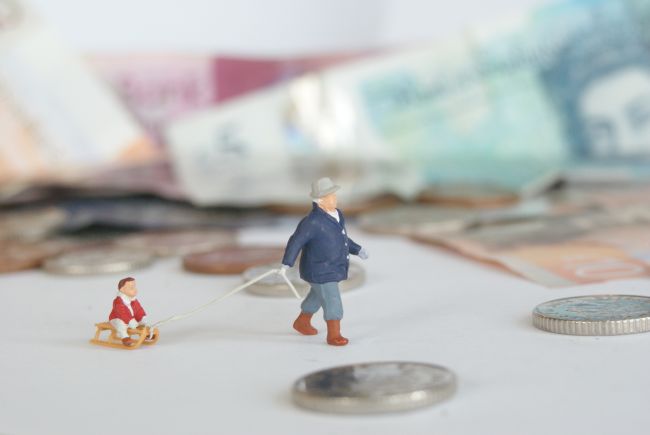 Small model figures walking past bank notes