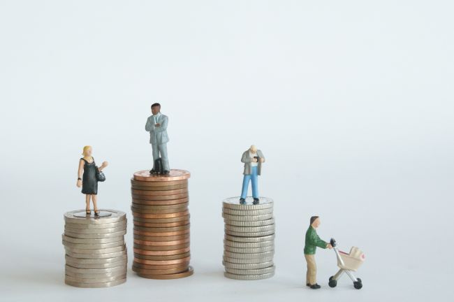 Small model figures standing on stacks of coins