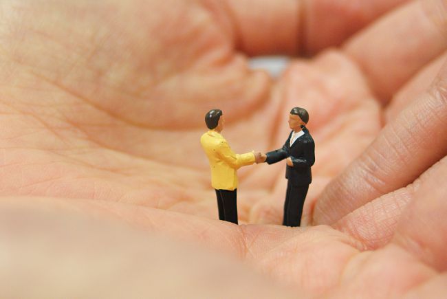 Small model figures shaking hands