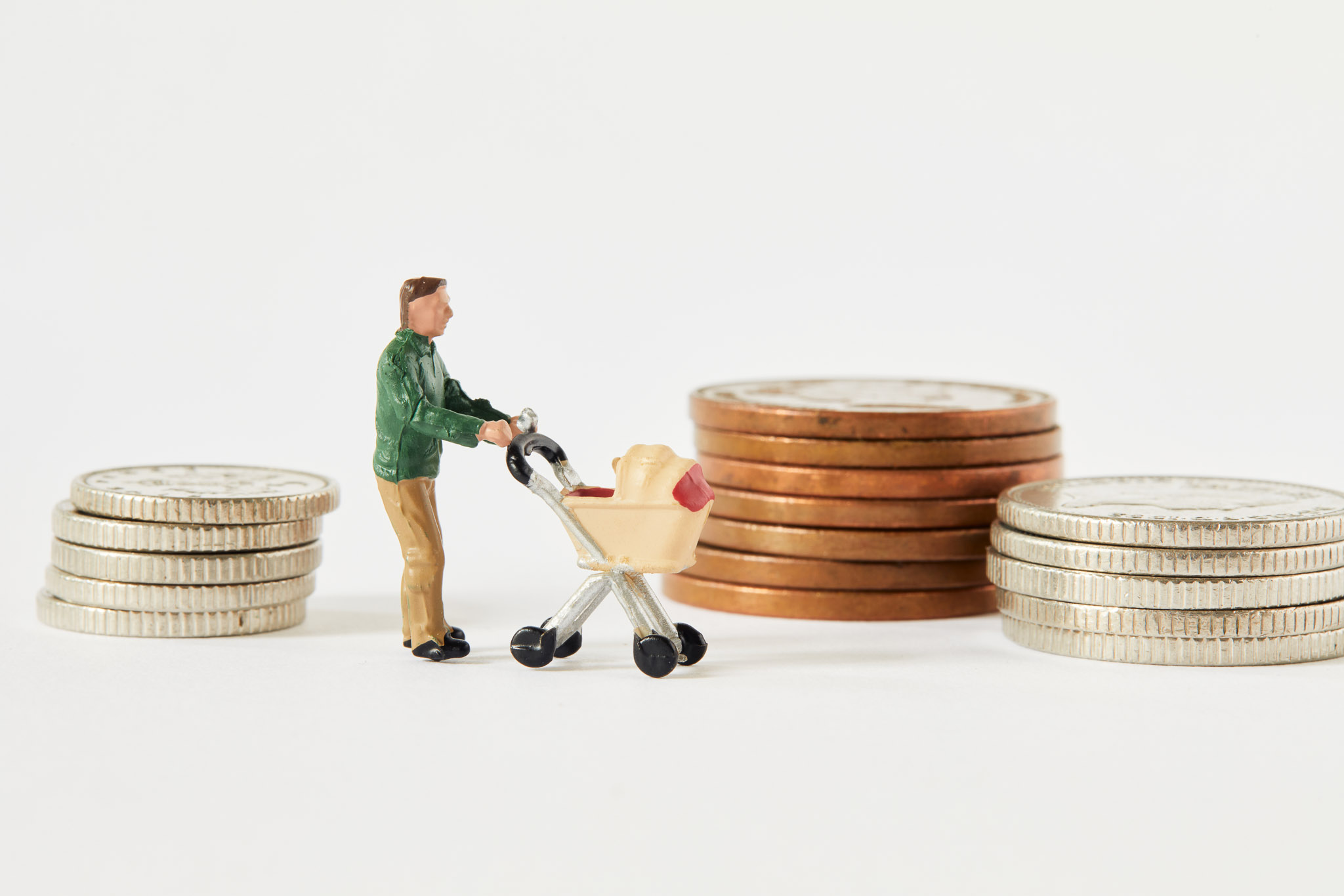 Small figurine of a parent pushing a buggy surrounded by piles of coins