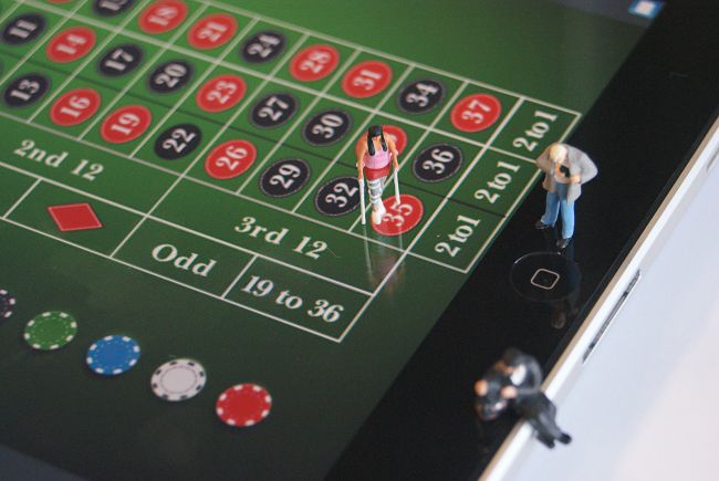 Small model figures standing on casino game table