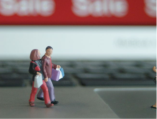 Small model figures walking across laptop keyboard