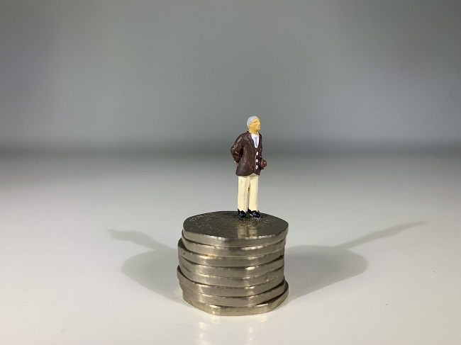 figure next to a stack of coins