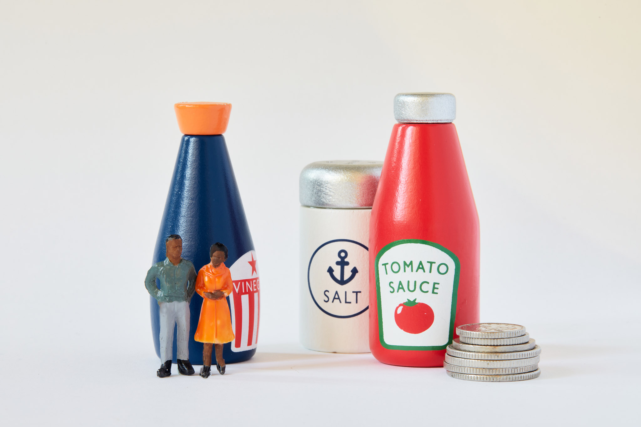 Small figurines standing in front of condiments and coins